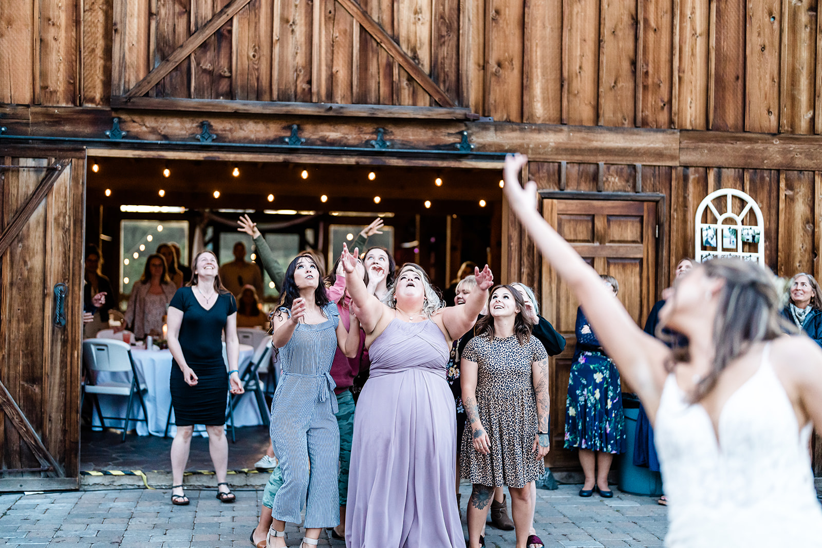Bride throwing the bouquet at a Cattle Barn Wedding