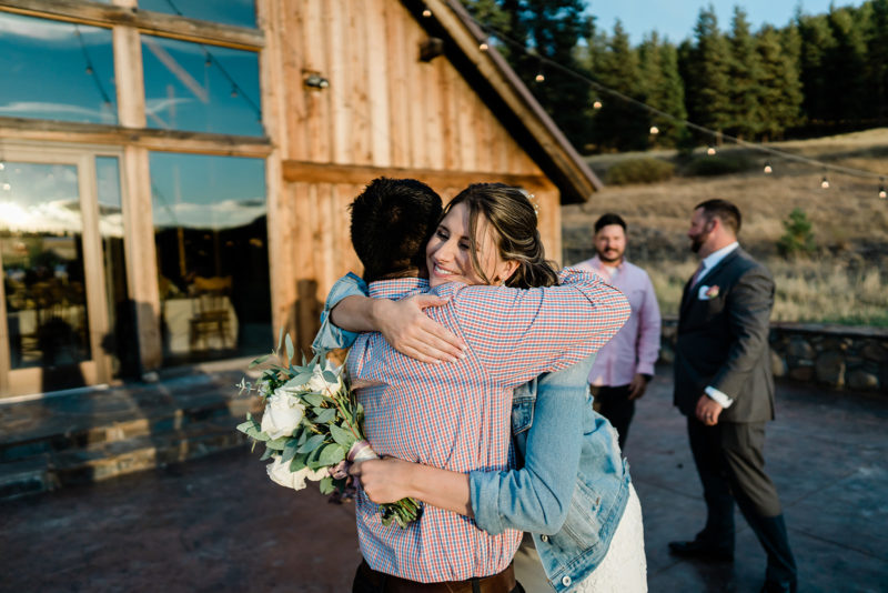 Bride hugging guest at a Cattle Barn Wedding