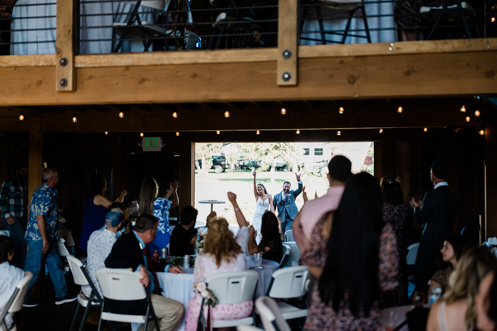 Guests cheering couple at a Cattle Barn Wedding