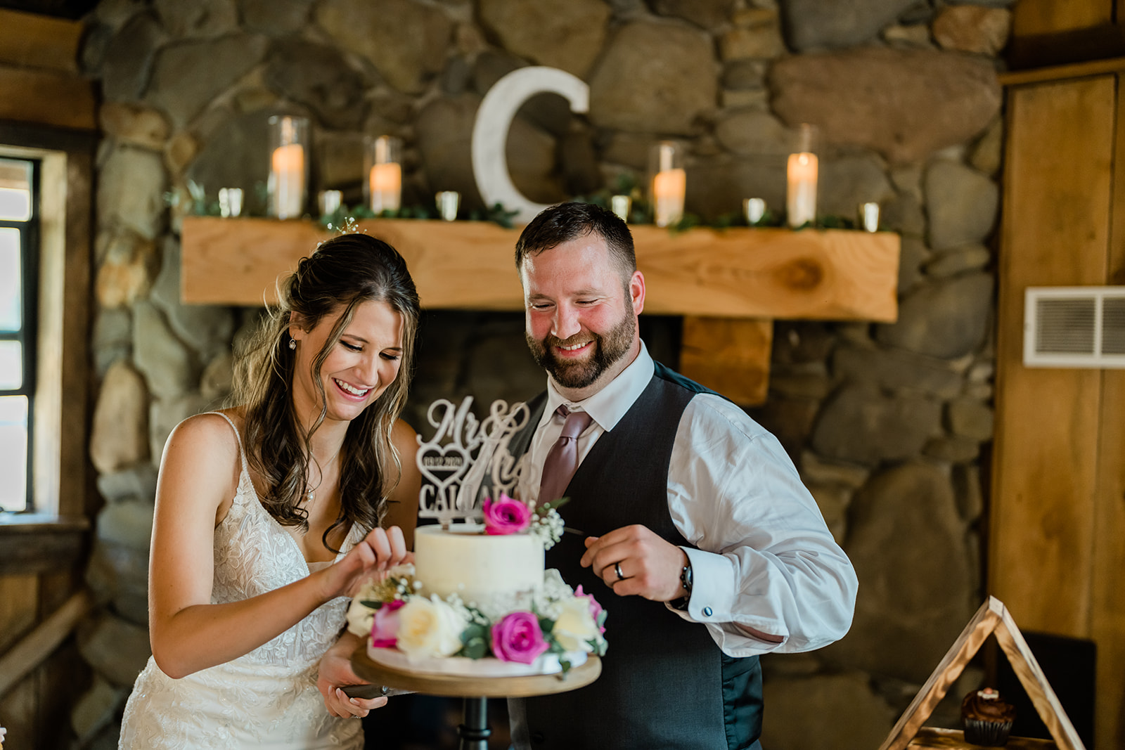 Bride and Groom cutting the cake at a Cattle Barn Wedding