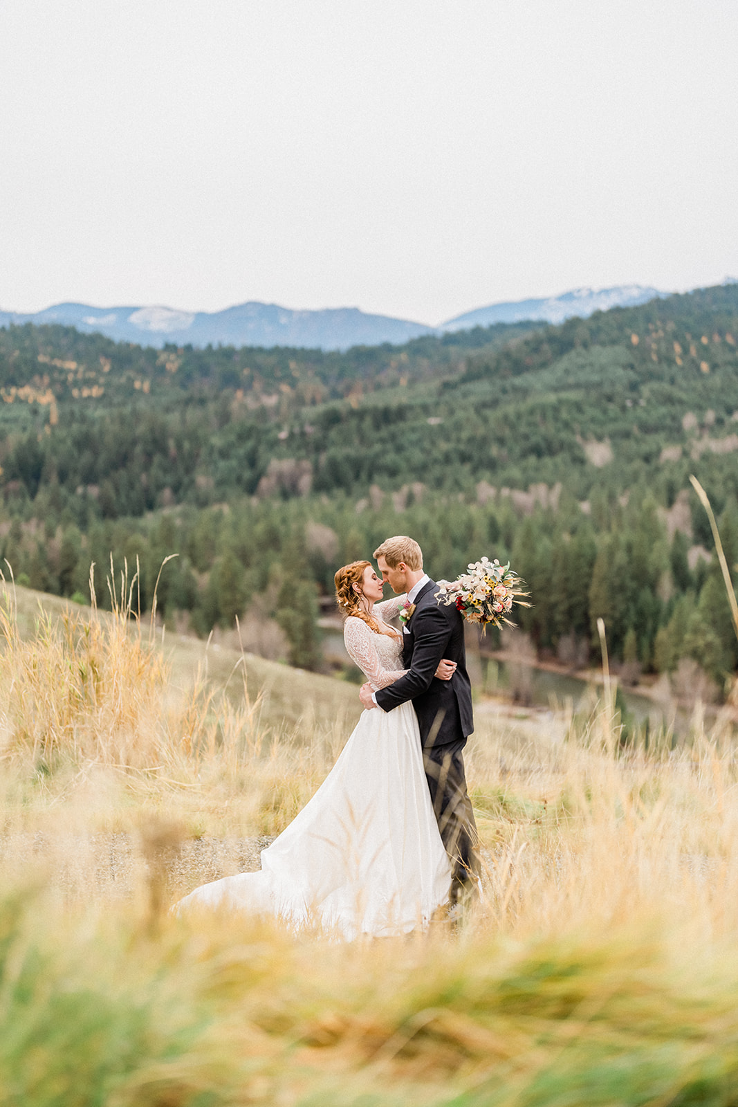 Bride and groom on the hills embracing in a hug outside of Swiftwater Cellars
