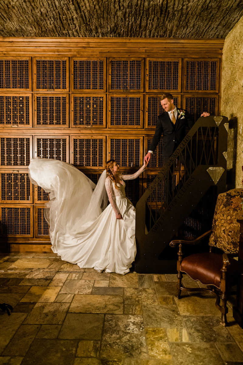 Bride and groom climb the staircase inside Swiftwater Cellars