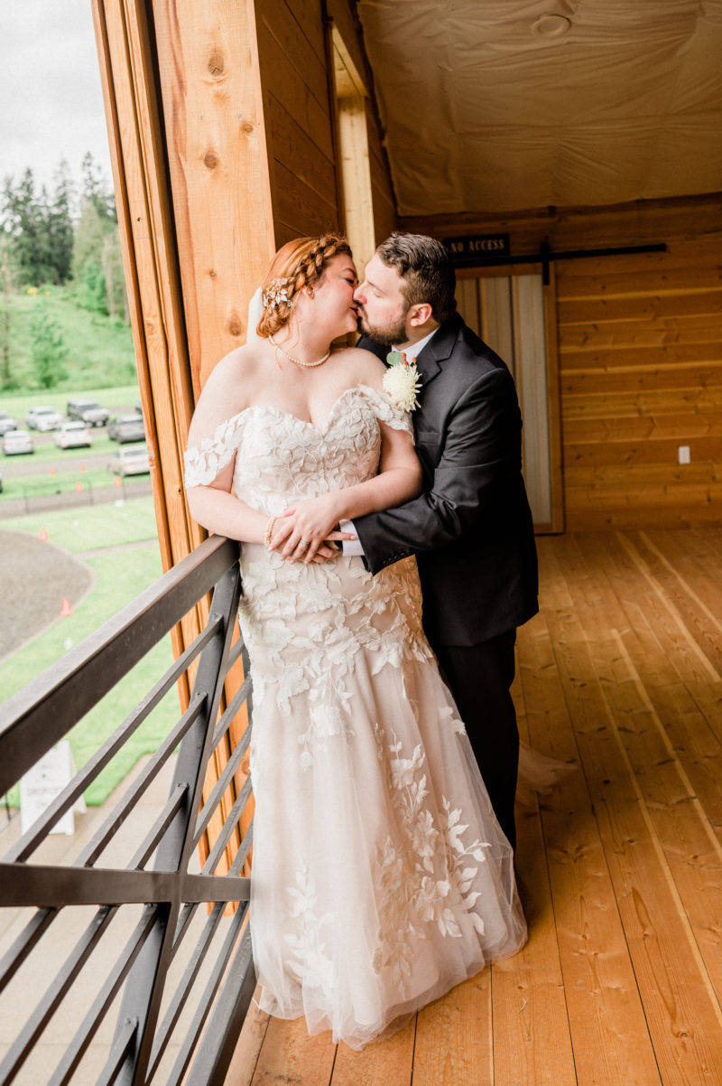 Couple kissing in a barn at their wedding.