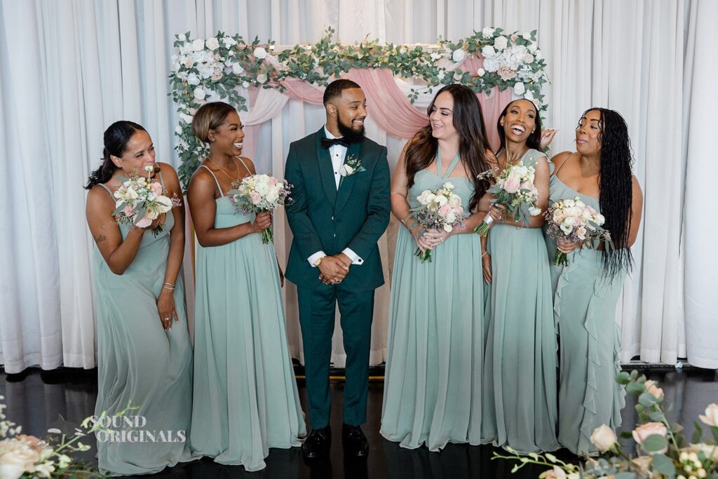 Groom poses candidly with the bridesmaids at Briza on the Bay Wedding