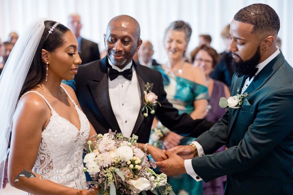 Father gives his daughter&#039;s hand to the groom at Briza on the Bay Wedding