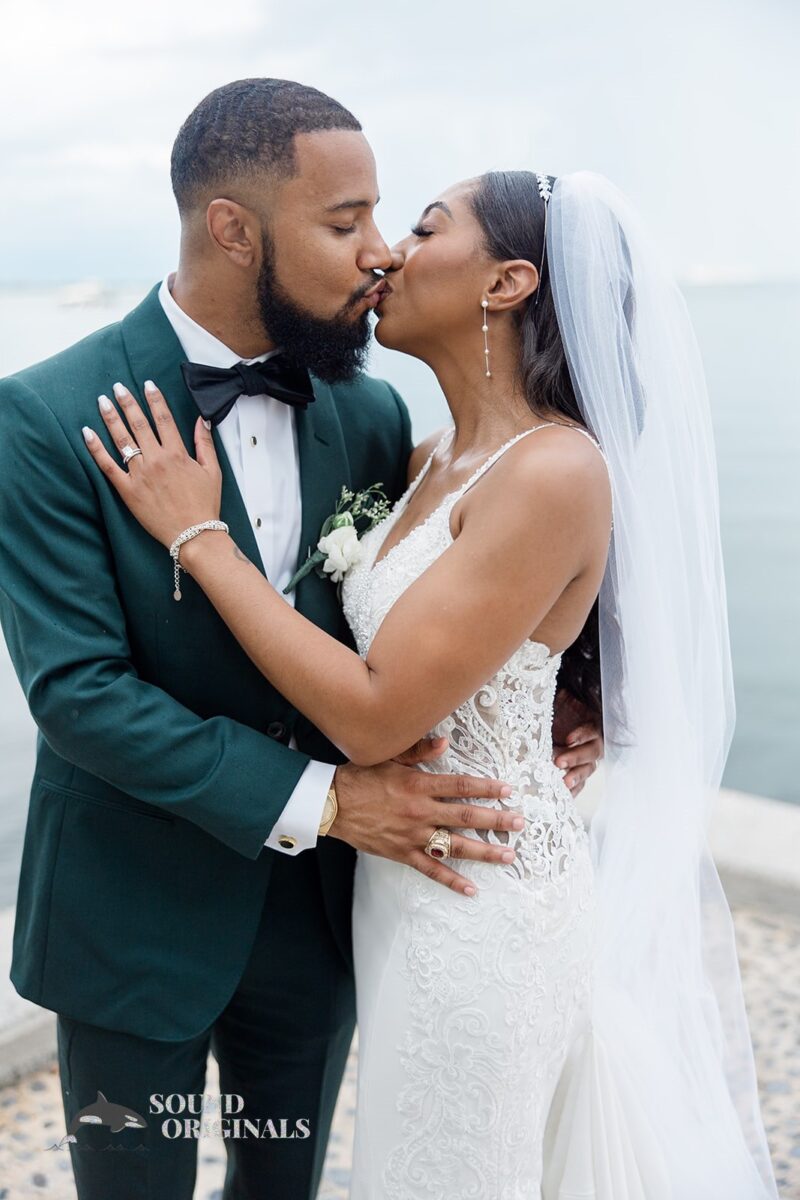 Newlyweds kiss at the bay at Briza on the Bay Wedding