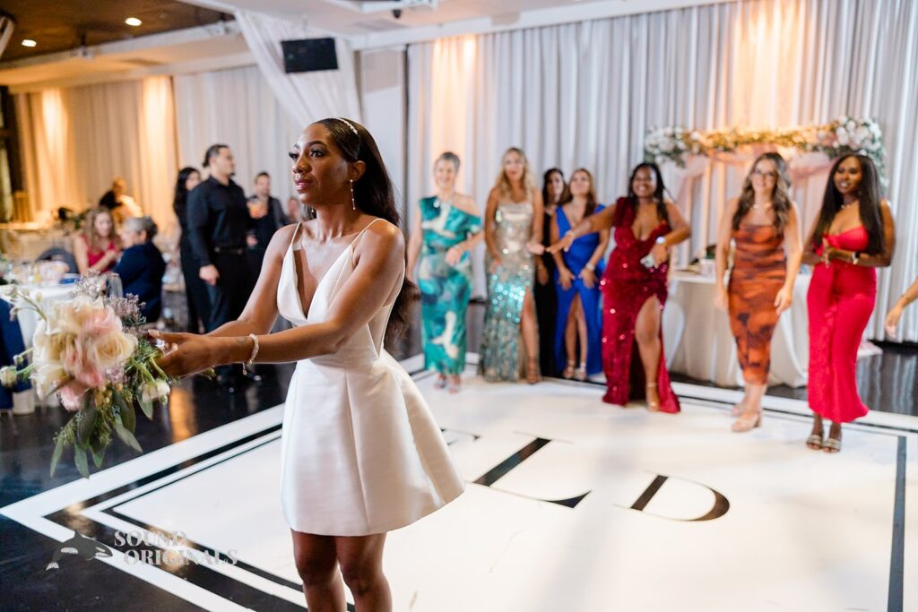 Bride does the bouquet toss at Briza on the Bay Wedding