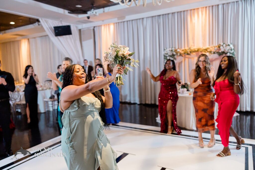 A bridesmaid catches the bouquet at Briza on the Bay Wedding