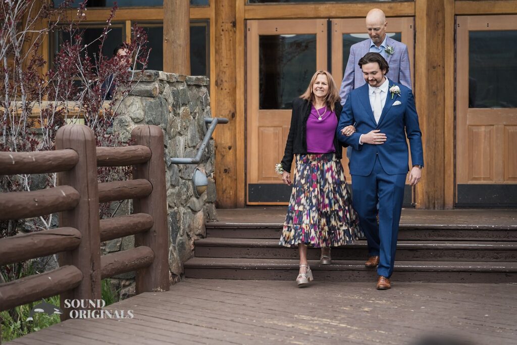 Groom and parents walking out of the Evergreen Lake House building to the outdoors for the Evergreen Lake House Wedding