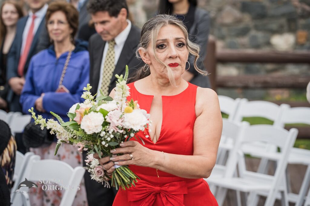 Photographer captures moment bride&#039;s mum holds the wedding flowers in Evergreen Lake House Wedding