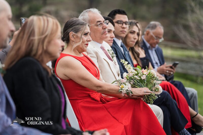 Bride parents and guests in awe as bride and groom exchange marital vows in Evergreen Lake House Wedding