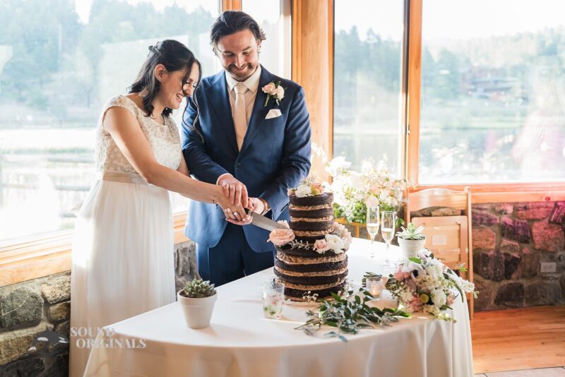 Bride and groom cut the cake in Evergreen Lake House Wedding reception