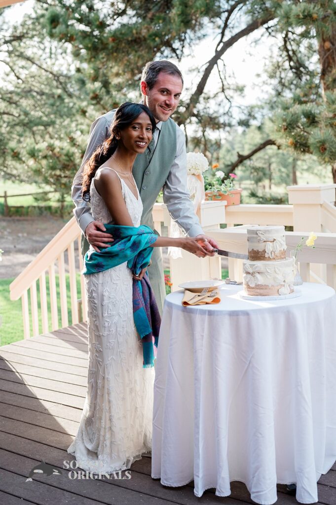 Bride and groom cut two tier wedding cake at The Red Farmhouse Bed & Breakfast Wedding