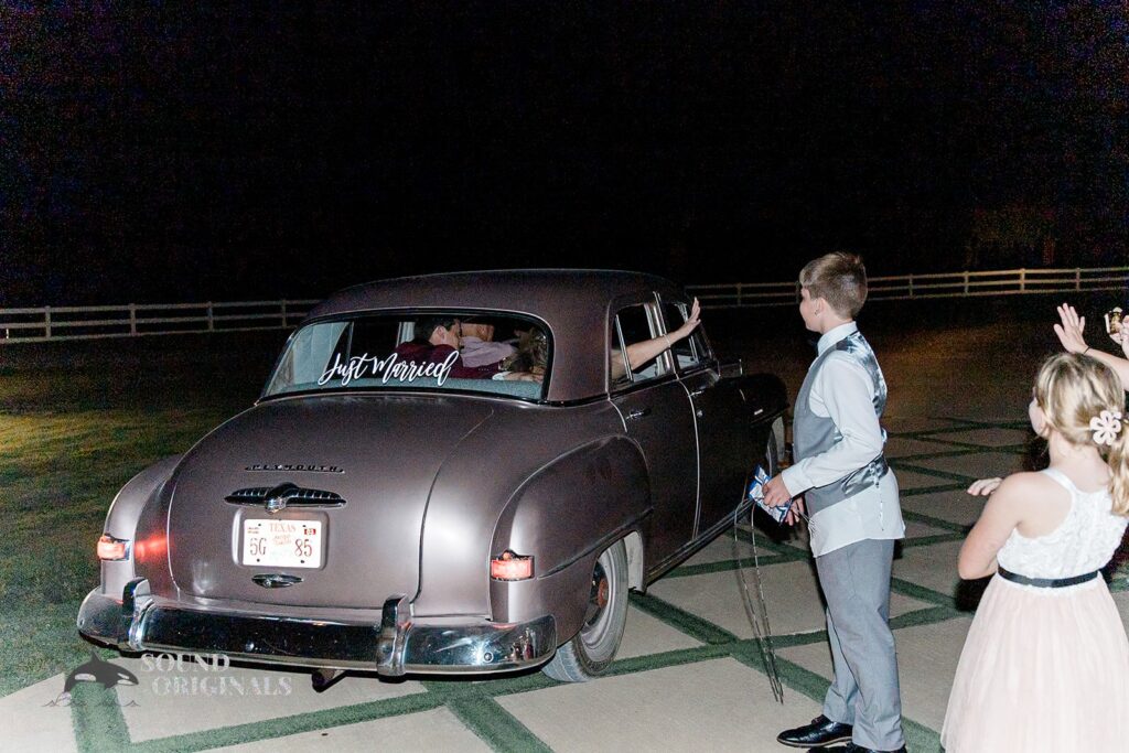 Husband and wife drive off the wedding venue after a successful French Farmhouse Wedding