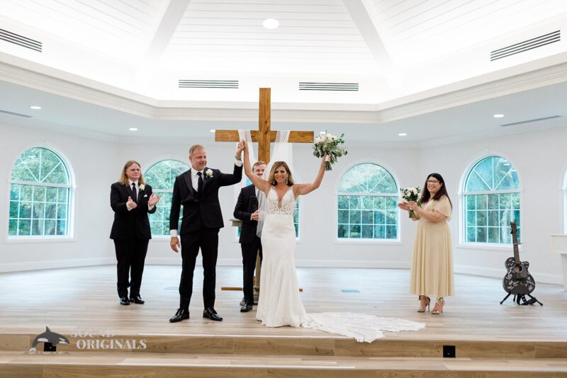 The newlyweds raise their hands for a scuccessful Harborside Chapel Wedding